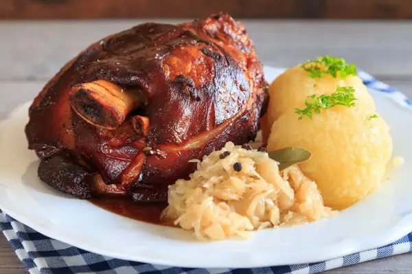 Knusprige Schweinshaxe mit Klößen und Sauerkraut. Ein köstliches Schweinshaxe Rezept für Genießer.