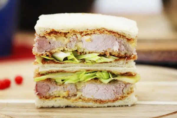 Ein saftiges Katsu Sando mit knusprigem Schnitzel, frischem Kohl und weichem Brot. Ein Genuss für jeden Feinschmecker!